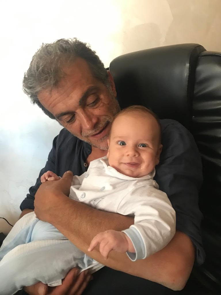 Un padre tiene in braccio il figlio sorridente